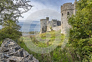 A view towards the Carew estuary between a dry stone wall and the ruins of Carew Castle, Pembrokeshire, UK