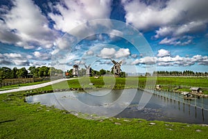 View towards Collection of old windmills at Angla Windmill Hill on a sunny day with blue sky and clouds in Saaremaa