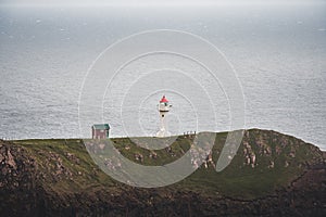 View towards orange house on Akraberg lighthouse at Suduroy island at summer, Faroe Islands.