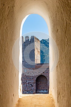 View at a tower, a brick wall and stones with an arch-shaped niche with stones seen from a window