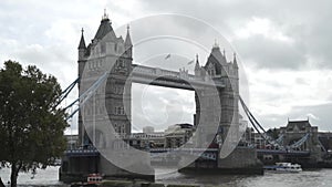 View of the Tower Bridge and traffic above the Thames against the cloudy sky in summer day in the center of London