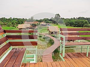 View from the tower with seating for a bird`s-eye view of the place That has a thatched roof hut In the rice fields that are growi