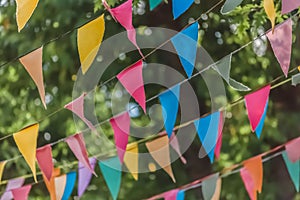 View of traditional decoration of popular festivals of the villages, with colored triangles of paper hanging in threads, blurred