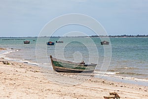 View of traditional fishing boats floating on the edge of the Luanda bay beach, Mussulo island as background