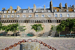 View of Traditional houses with chimneys inside the walled city of Saint Malo, with the cobbled pavement of Robert Surcouf Esplana