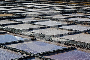 View on traditional rectangular salt evaporation ponds or salt pans creating a gridView on traditional rectangular salt