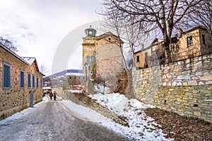 View of traditional stone buildings and streets with snow at the famous village of Nymfaio near Florina.