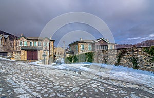 View of traditional stone buildings and streets with snow at the famous village of Nymfaio near Florina.