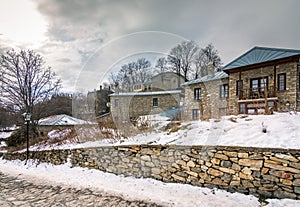 View of traditional stone buildings and streets with snow at the famous village of Nymfaio near Florina, Greece