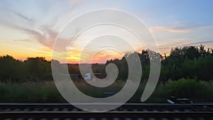 The view from the train on the beautiful scenery with hills and forest before sunset. The view from the window of the