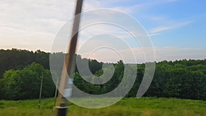 The view from the train on the beautiful scenery with hills and forest before sunset. The view from the window of the