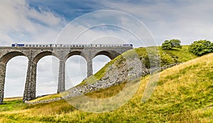 A view of a train exiting the Ribblehead Viaduct, Yorkshire, UK