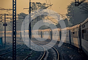 A view of a train in motion taking turn with graveled tracks and gloomy sky.