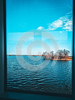 View from the window of the house on the lake and the sky with clouds