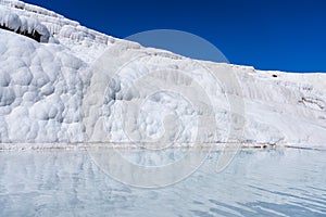 A view of the travertines. Pamukale, Turkey. Blue water in the terraces. A popular place for tourism.