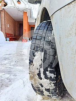 View of the tread of a winter car tire with adhered snow.