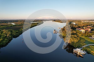 View of trees on the coasts of Manatee River under the blue sky reflected in the water