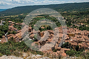 View of trees, house roofs and belfry in Moustiers-Sainte-Marie