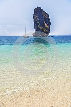 View of tropical beach and clear water and blue sky with limestone rock background at po da island , krabi Thailand