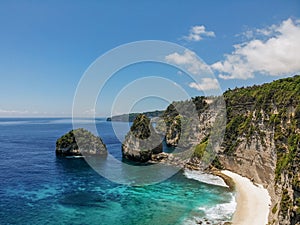View of tropical beach, sea rocks and turquoise ocean, blue sky. Atuh beach, Nusa Penida island, Bali, Indonesia. Tropical