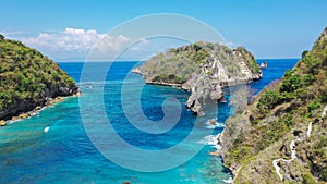 View of tropical beach, sea rocks and turquoise ocean, blue sky. Atuh beach, Nusa Penida island, is located to the
