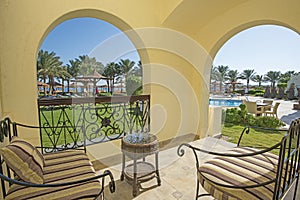 View of a tropical beach and swimming pool from hotel room