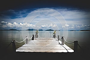 View from tropical island over wood pier on endless ocean water with dramatic storm sky clouds - Thailand, andaman sea