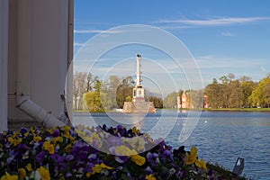 View from the Turkish bath Pavilion and flowers on the Chesma column of Catherine Park, standing in the lake