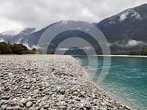 View of turquoise blue creek and foggy mountains