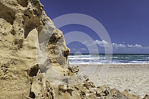 View of the turquoise waters of the Mediterranean Sea through sand formations on the shore