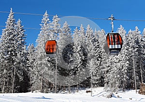 Dve kabínkové lanovky a zasnežené smreky v lyžiarskom stredisku