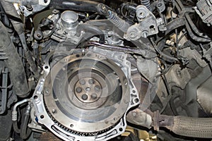 View of a two-mass damper flywheel in the engine compartment of a car with the gearbox removed