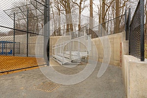 View of typical nondescript high school softball field aluminum bleachers l