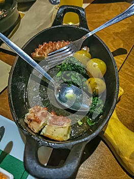 View of a typical Portuguese dish with grilled octopus, potato, spinach and garlic photo