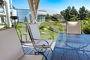 View from under canopy of patio of summer landscaped garden next to country mansion