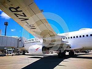 The view under the plane left wing of Qantas domestic airline Aircraft Type: Boeing 737 on the runway.