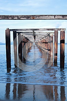 view from under the wooden pier with beach landscape and waves on the batu payung Mimiland, west kalimantan