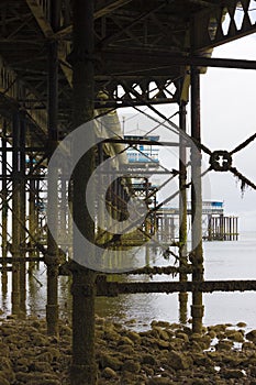 View from underneath the complex structure of iron columns holding the Grade II Listed Llandudno Pier in place