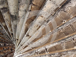 View underneath old eroded brown worn concrete spiral stairs forming a geometric abstract