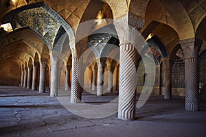 View of the unique interior architecture of Vakil Mosque with large columns and beautiful Iranian tiles, Shiraz, Iran.