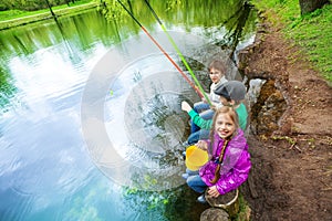 View from up of kids holding fishing tackles