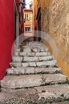 View up on stairs in narrow street between new red and shabby ye