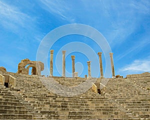 Stairs, viewing stands and columns against blue sky at ancient Roman theater of Leptis Magna in Libya photo
