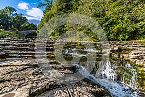 A view of the upper falls and old arch bridge at Stainforth Force, Yorkshire