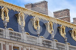 View of upper side of exterior facade of Versailles Palace with golden windows