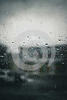 View of an urban landscape through a window is seen with droplets of rain.