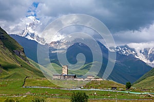 View of the Ushguli village at the foot of Mt. Shkhara. Lamaria Monastery, old Rock tower