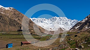 View of the Ushguli village at the foot of Mt. Shkhara. Lamaria Monastery, old Rock tower