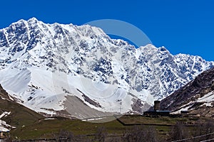 View of the Ushguli village at the foot of Mt. Shkhara. Lamaria Monastery, old Rock tower