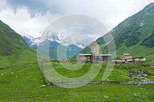 View of the Ushguli village at the foot of Mt. Shkhara. Lamaria Monastery, Rock tower towers and old houses in Ushguli